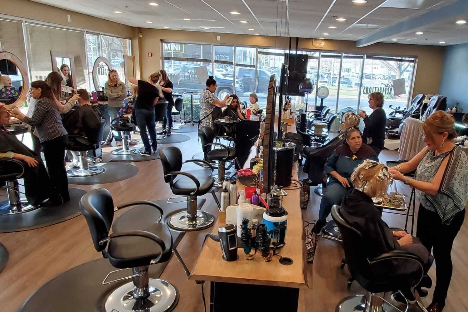Hair salon with stylists working, clients receiving various hair treatments.