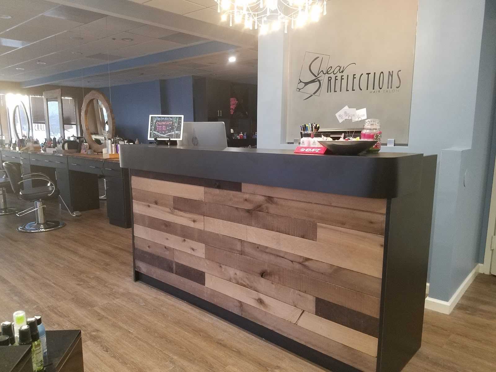 Salon reception area with wooden desk and styling chairs in the background.