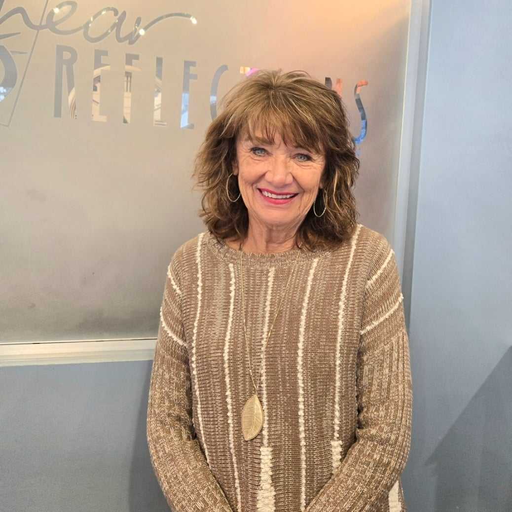 Portrait of Carol, a professional stylist at Shear Reflections Hair Salon, showcasing their expertise and style.